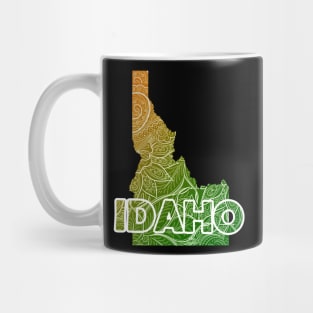 Colorful mandala art map of Idaho with text in green and orange Mug